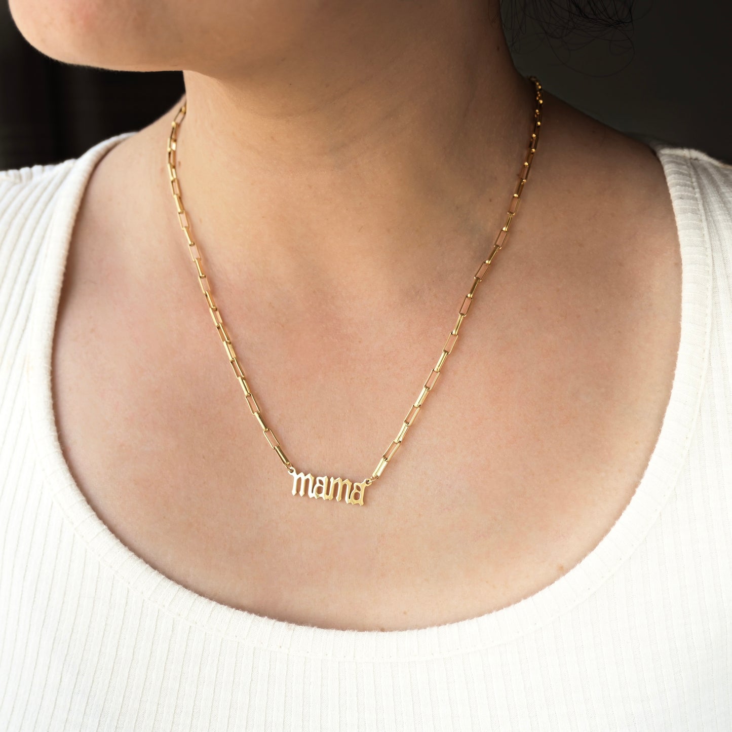 Small thick paperclip chain necklace with 'mama' on a person wearing a white top