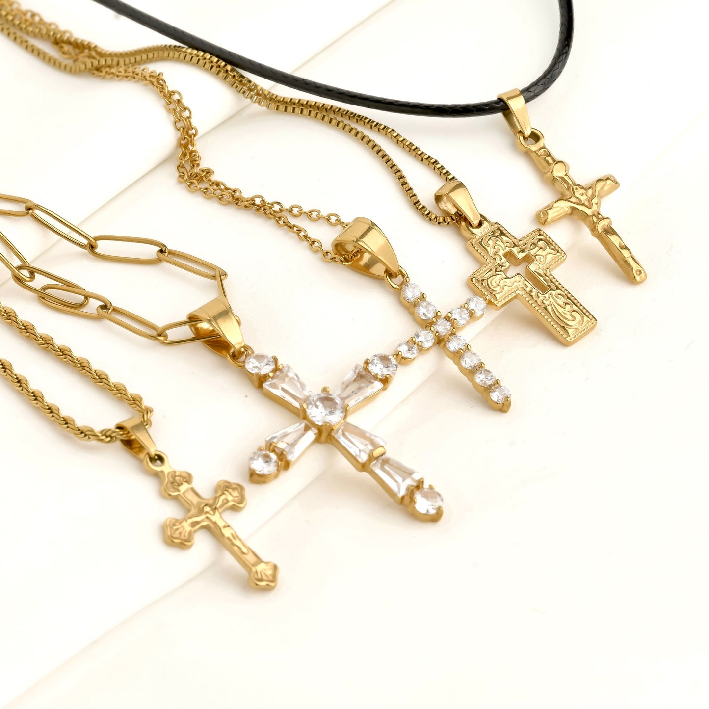 Gold necklaces with cross pendants on a white background