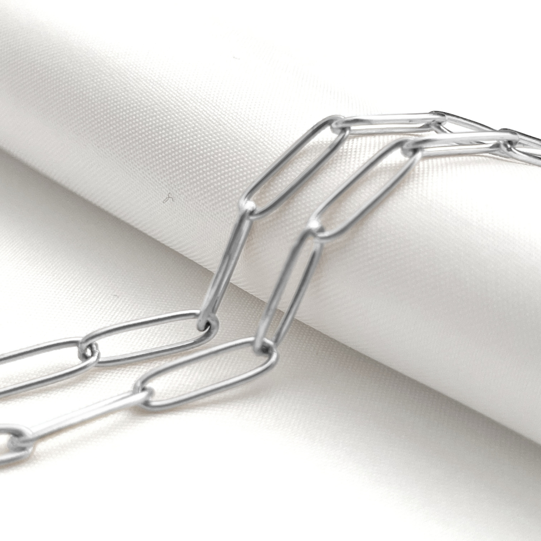 Stainless steel paperclip chain on a white fabric background