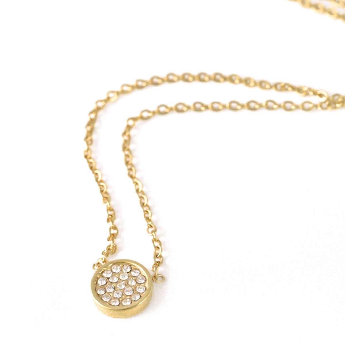 A gold chain necklace with a small round pavé pendant on a clean white background.