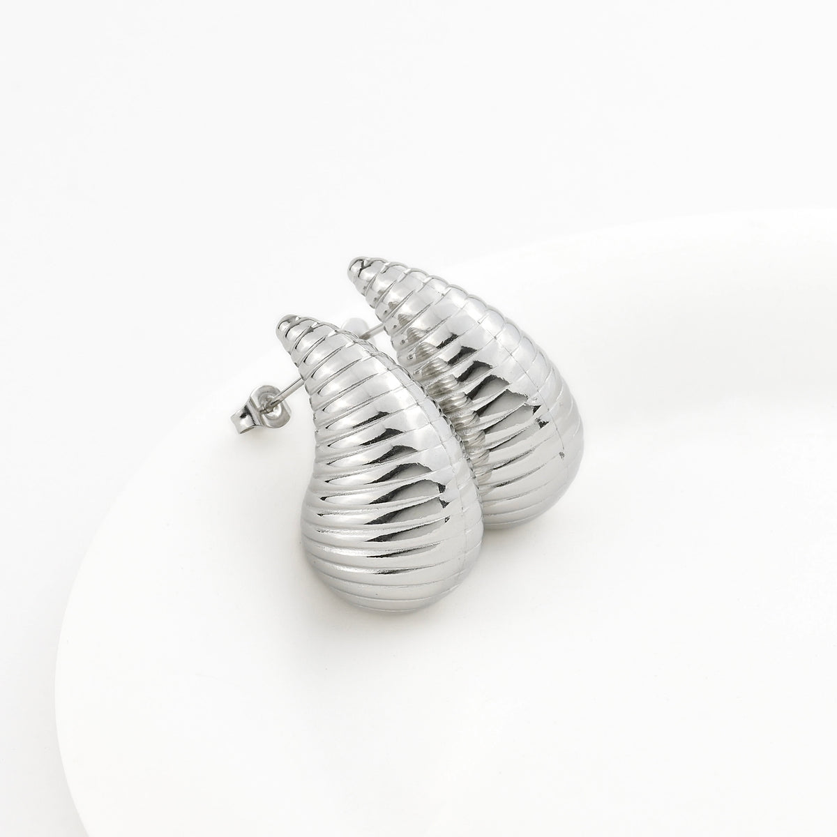 Silver shell-shaped earrings on a white background
