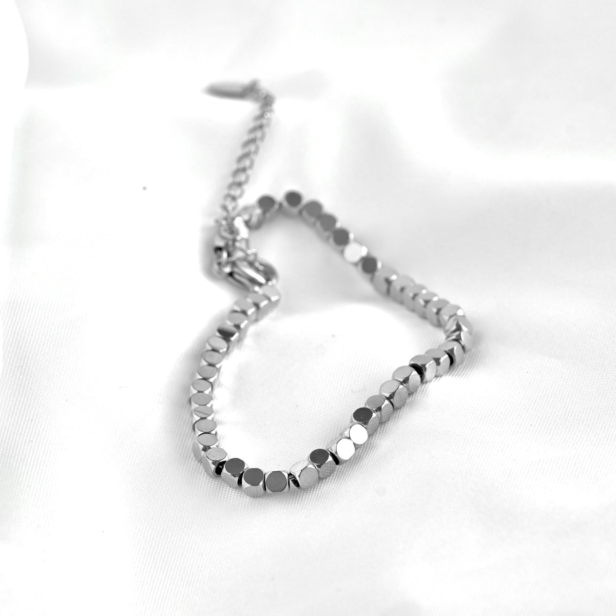 Silver square beaded bracelet on a white background