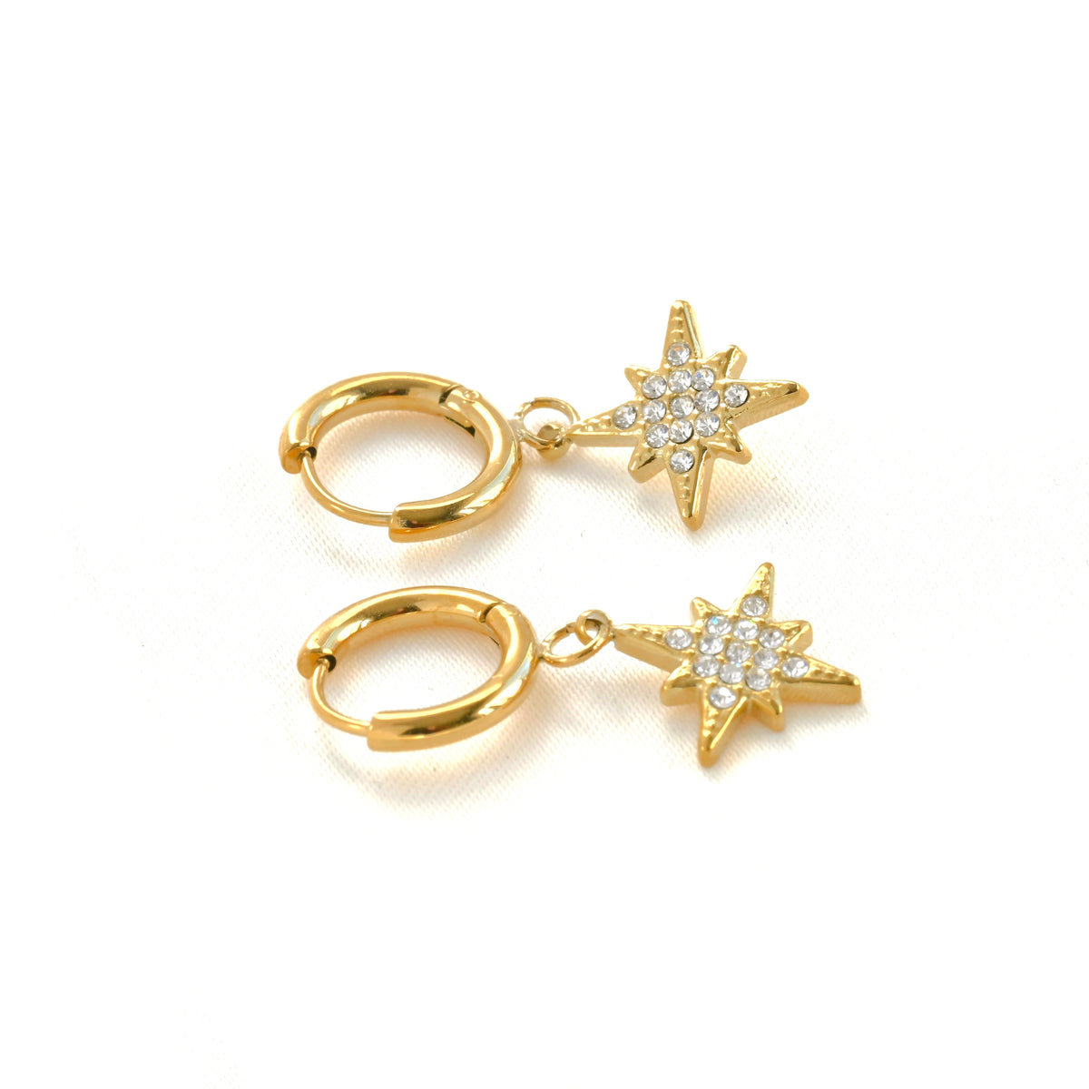 Gold star charm hoop earrings on white background