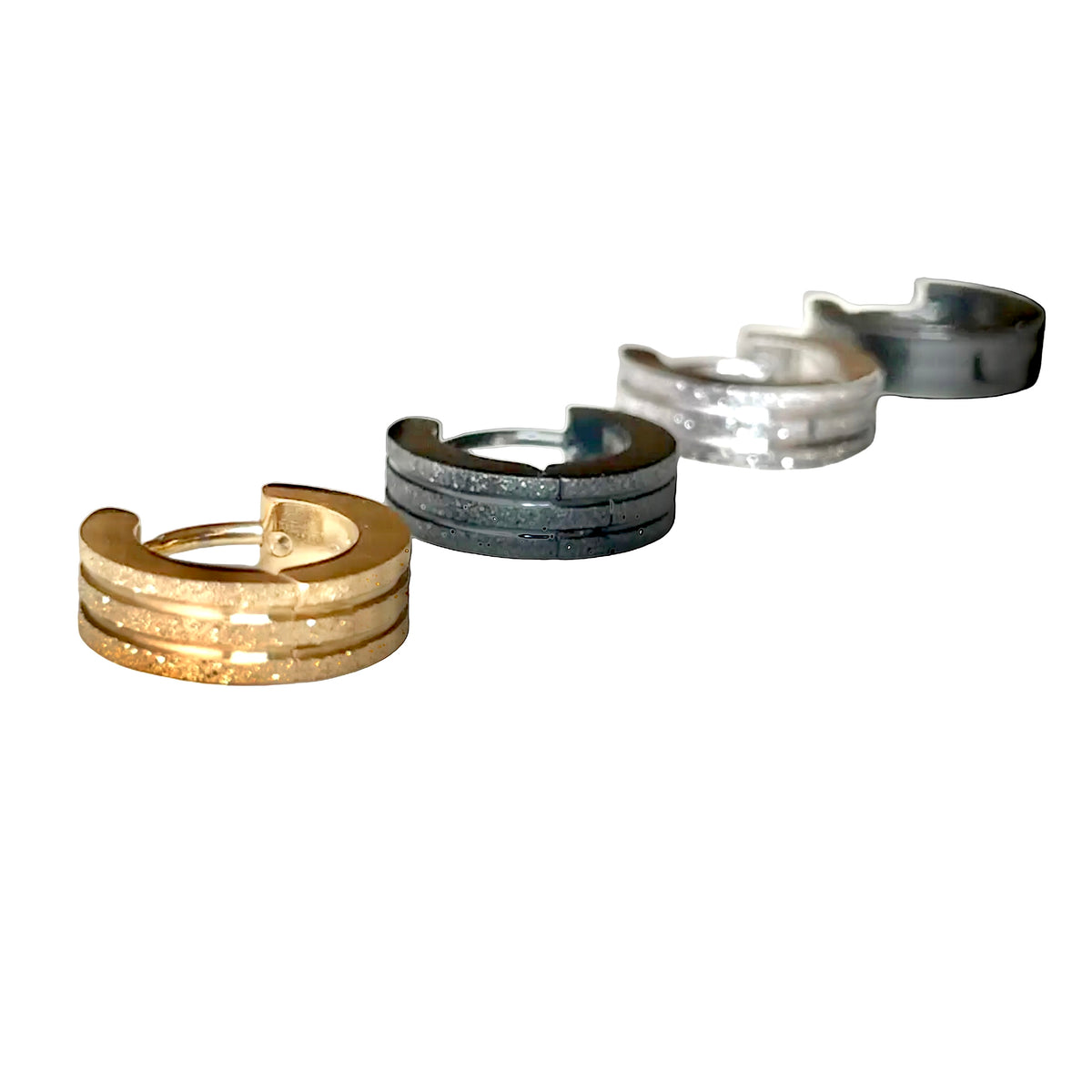 Set of four metallic huggie earrings in gold, silver, and gray on a white background
