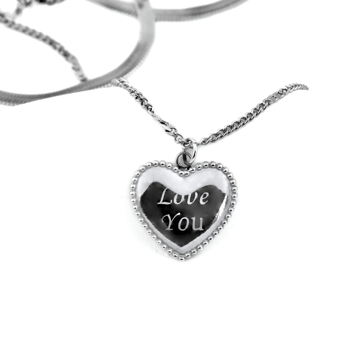 Close- up of the beaded edge heart pendant with 'Love You' engraving on a white background