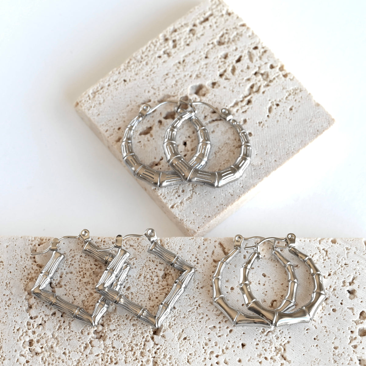 Three pairs of silver-toned hoop earrings with a textured, segmented geometric design, displayed on a white background with light beige stone tiles.