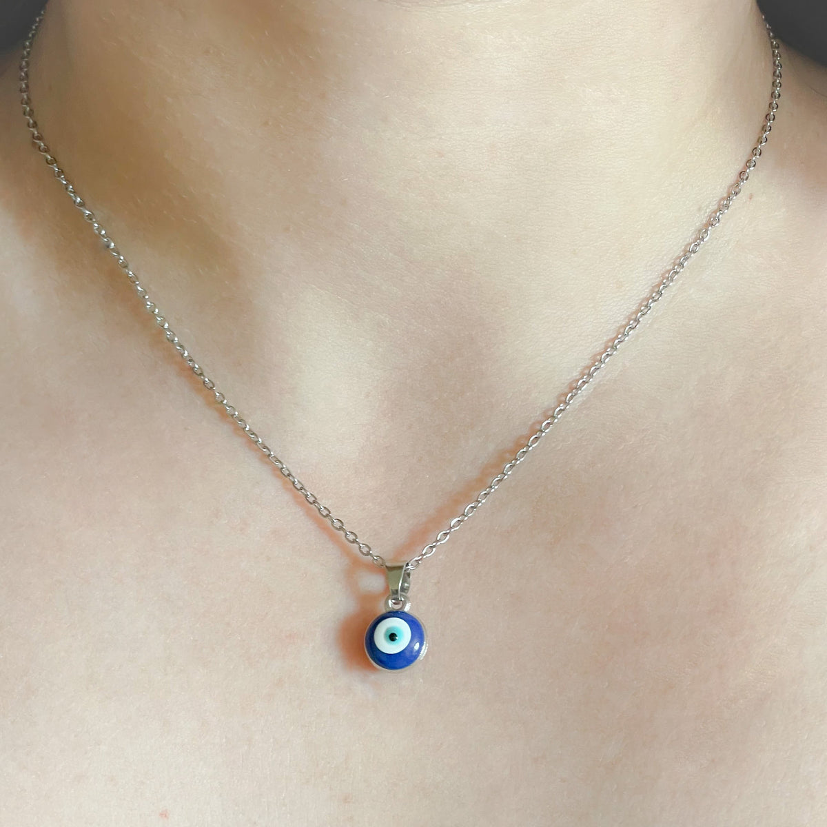 Necklace with a blue eye pendant on a person's neck