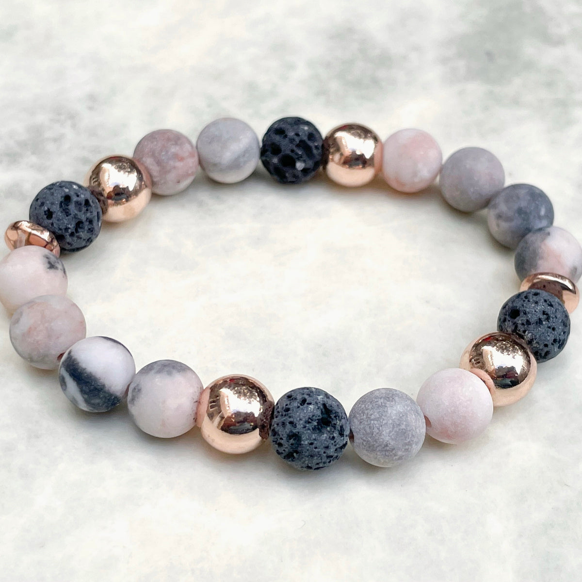 Pink gemstone bracelet with multicolored beads on a light gray background