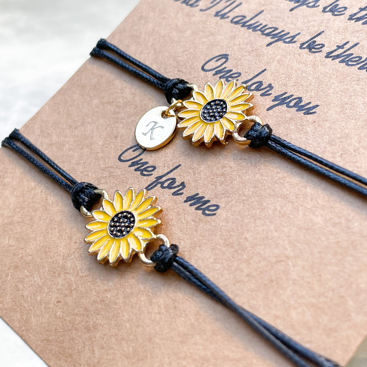 Angled close-up view of two flower friendship bracelets on a brown card with text