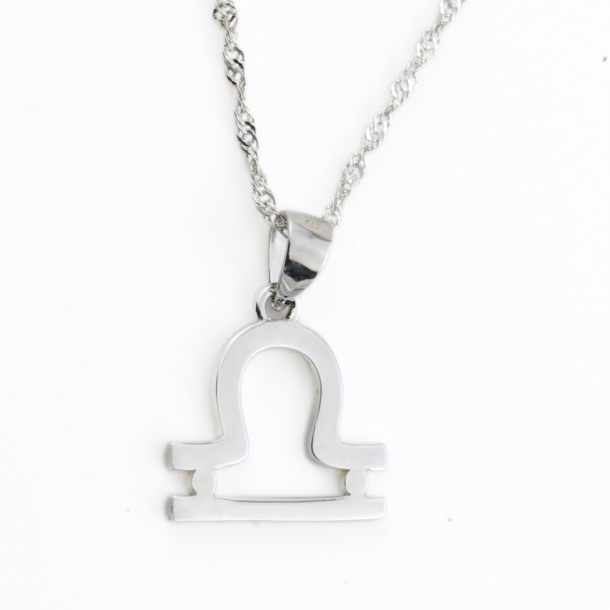 Silver Libra pendant necklace on a white background