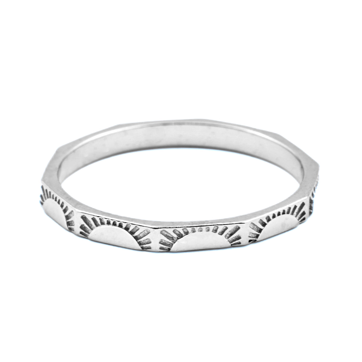 Angular silver sunburst ring with a textured design on a white background
