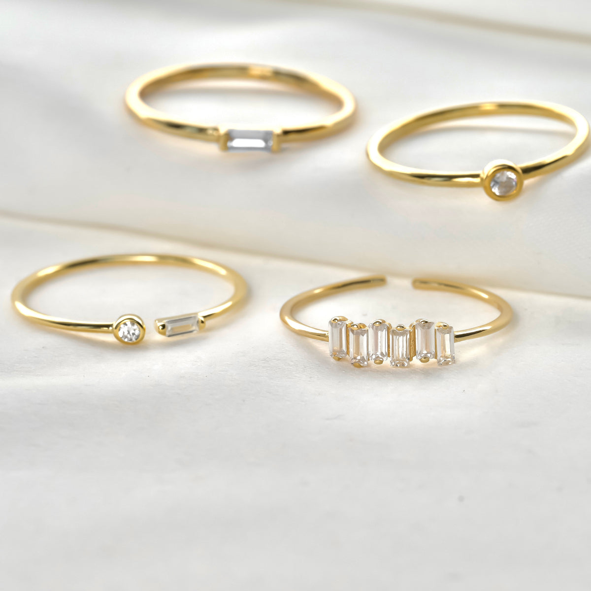 Close-up view of slim gold ringset with white gemstones on a light background