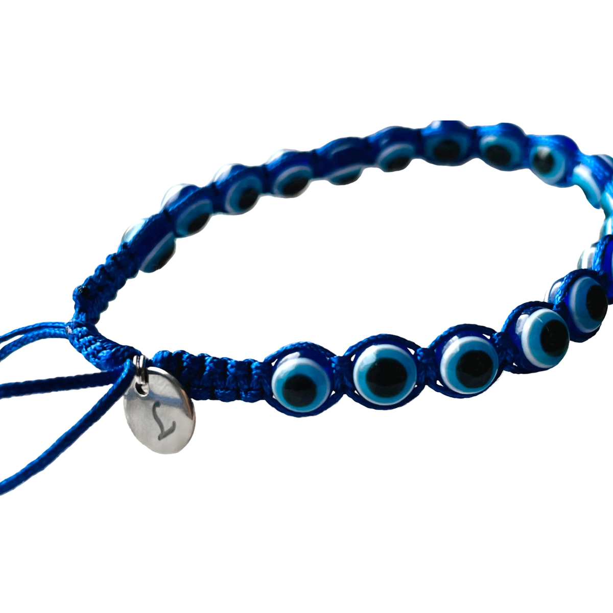 Close-up view of the initial charm attached to the sliding knot of the blue beaded bracelet on a white background