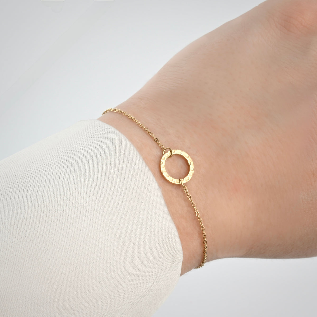 Gold bracelet with medium size hammered circle link on a wrist