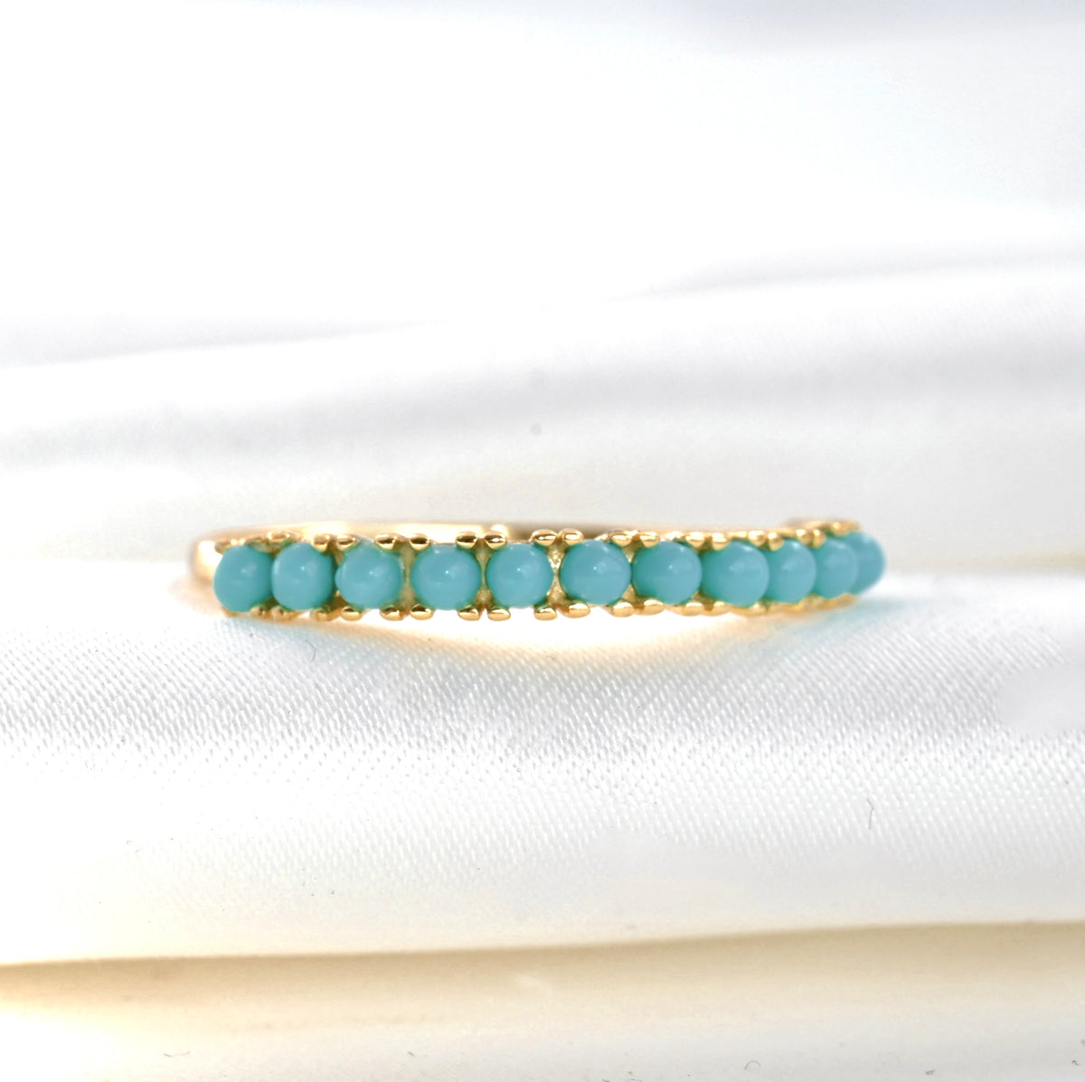front-close up view of the gold ring with vibrant turquoise stones