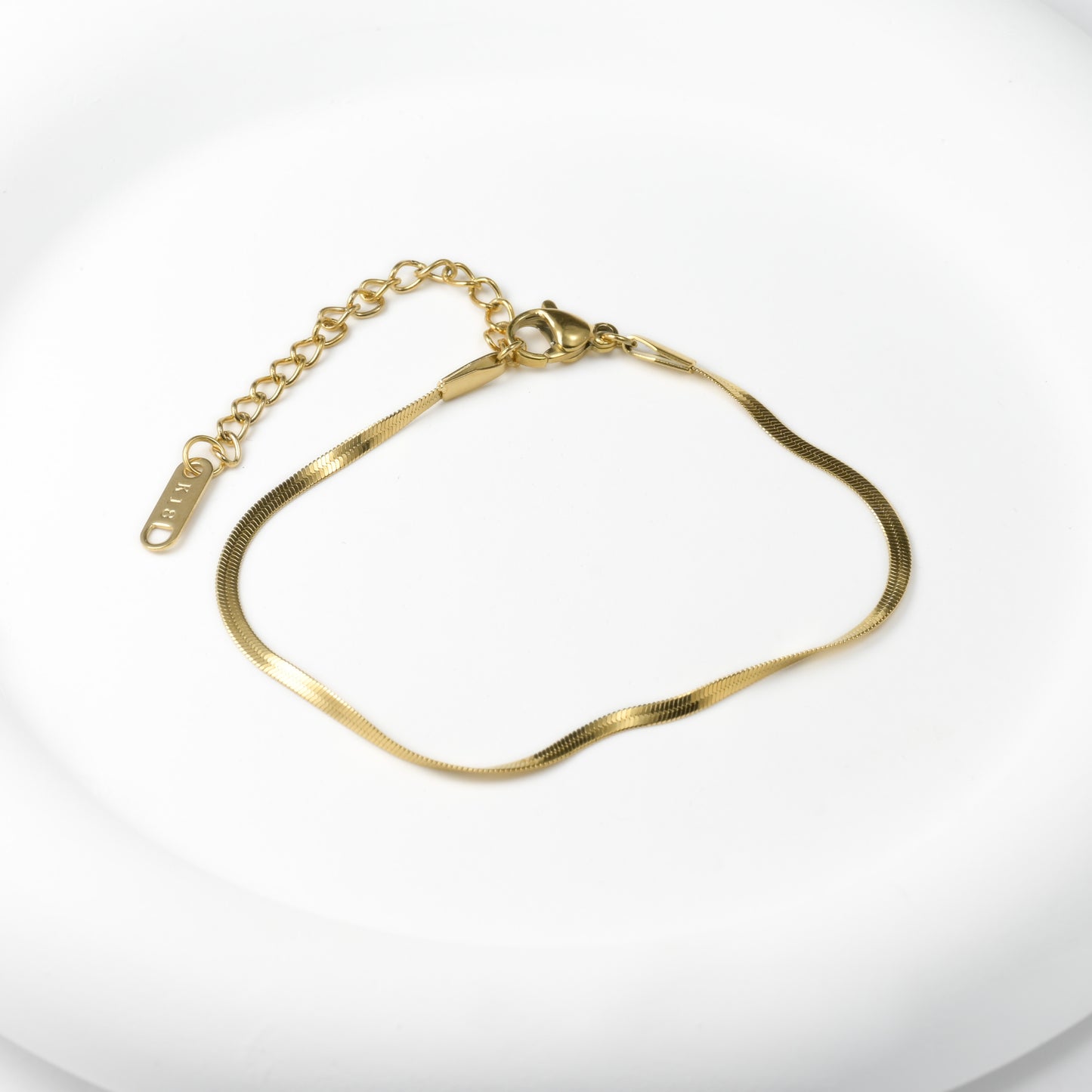 2mm gold herringbone bracelet on a white background