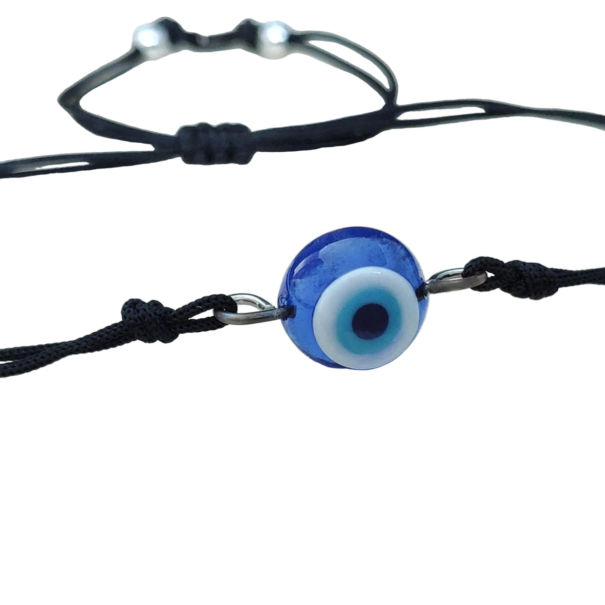 Close-up view of black cord bracelet with a blue evil eye charm showcasing the glass material of the charm on a white background