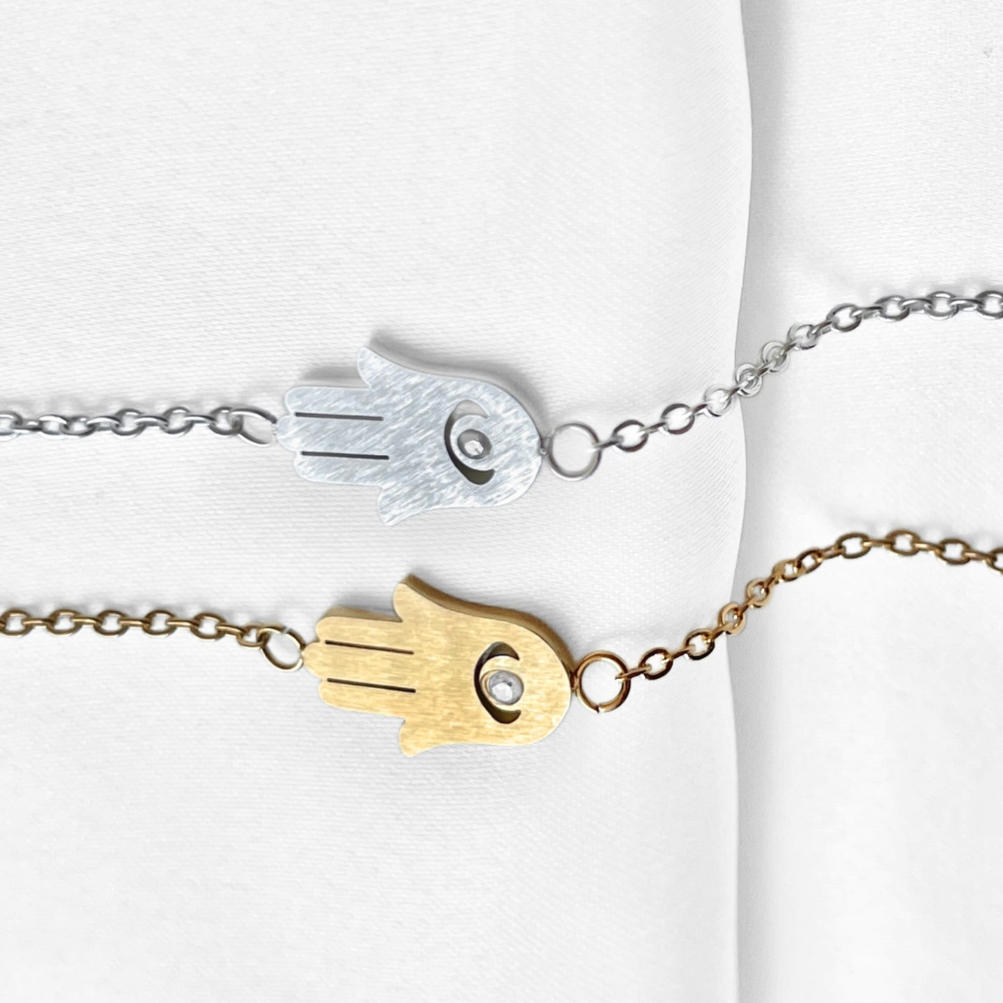 Gold and silver bracelet with Fatima's hand design on a white background