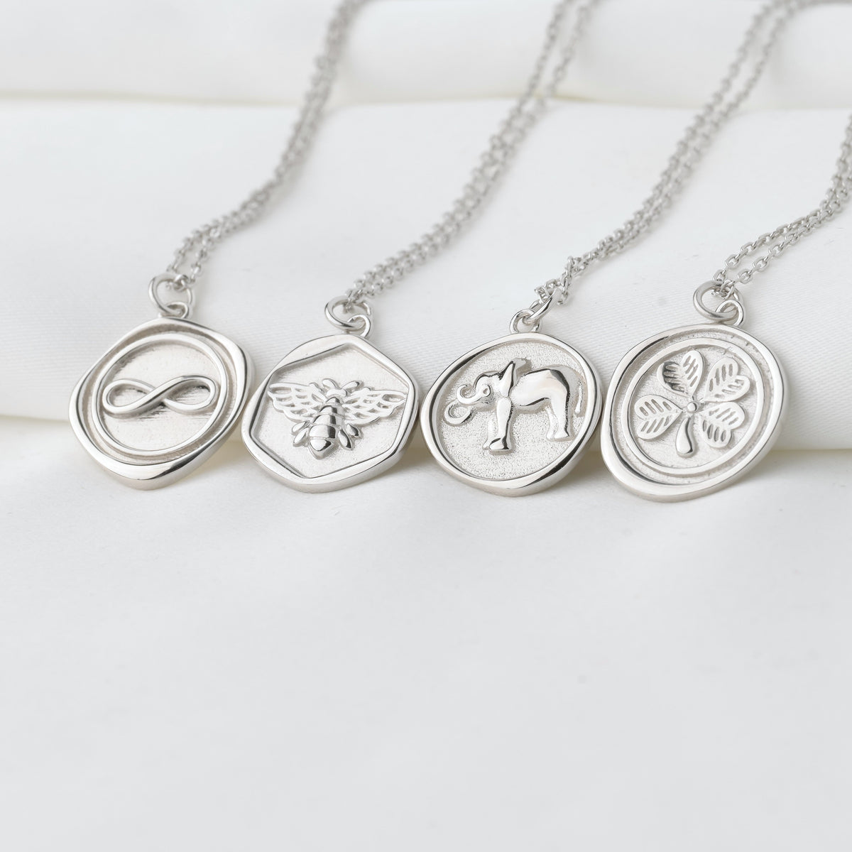 Silver necklaces with circular pendants on a white background