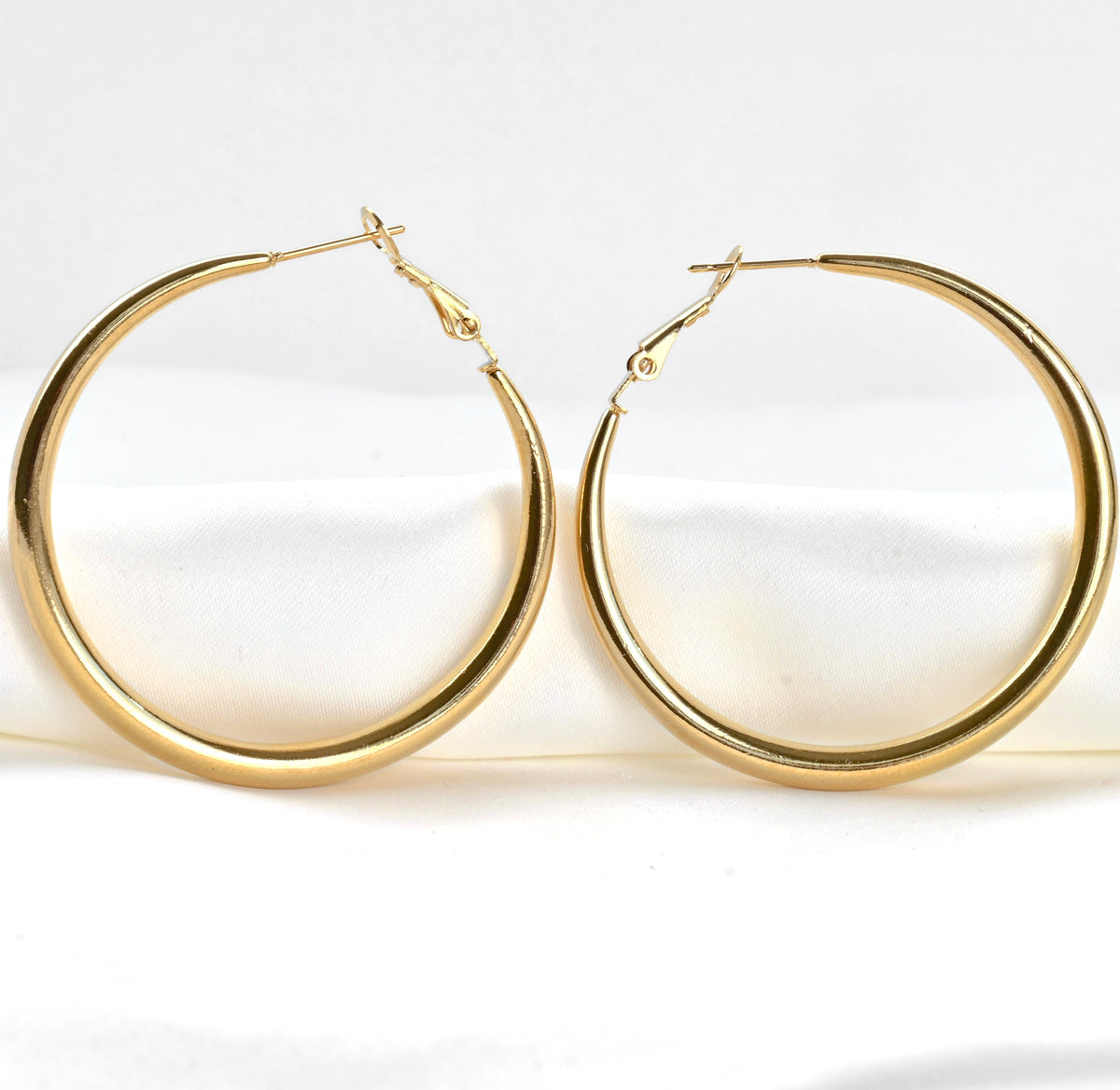 Close-up view of large hoop earrings on a white background