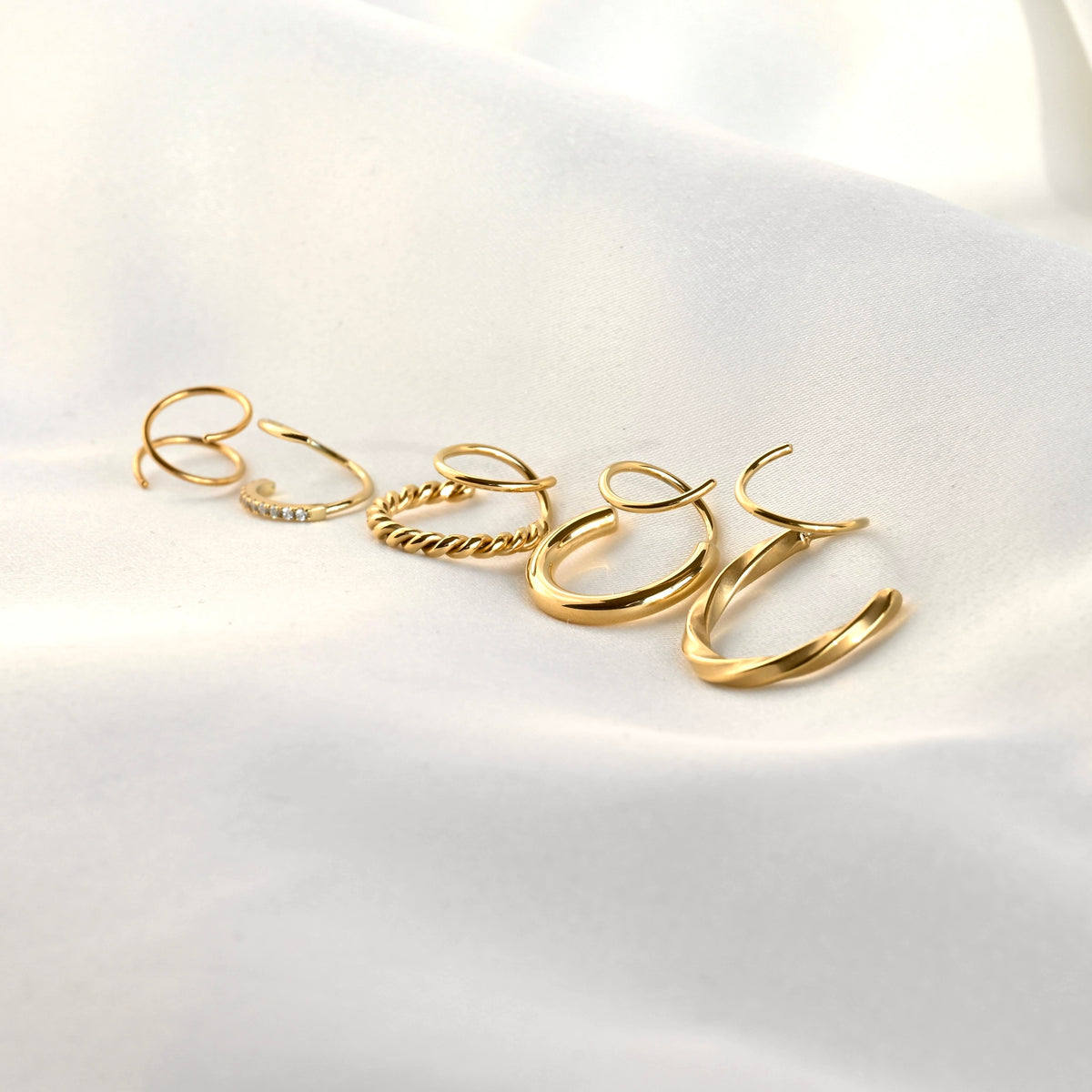 Set of gold double hoop illusion earrings on a white background
