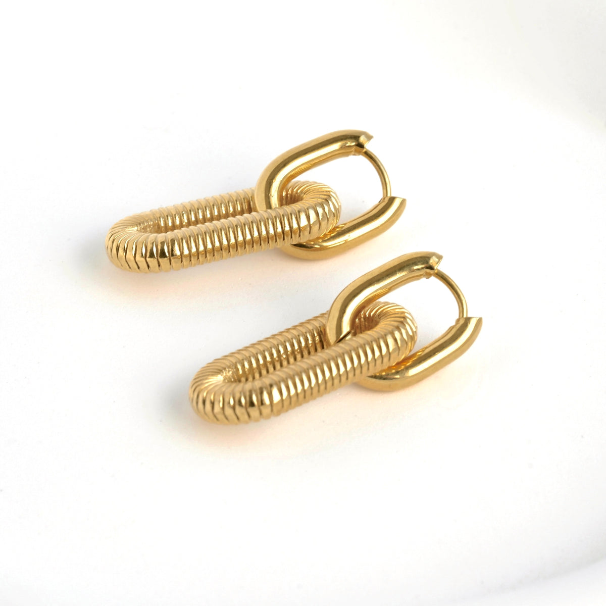 Pair of gold double hoop earrings on a white background