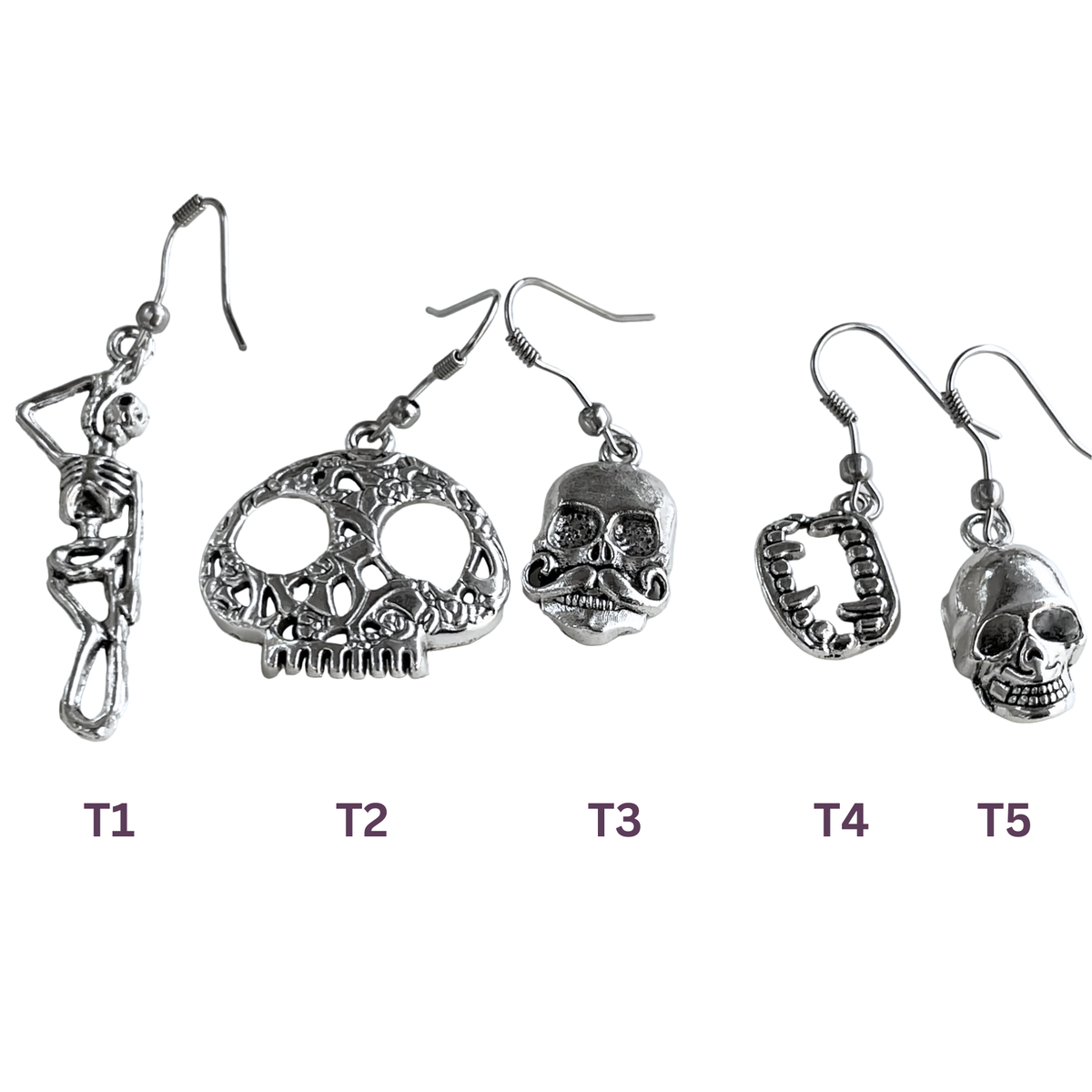 Set of five pairs of skull-themed earrings on a white background