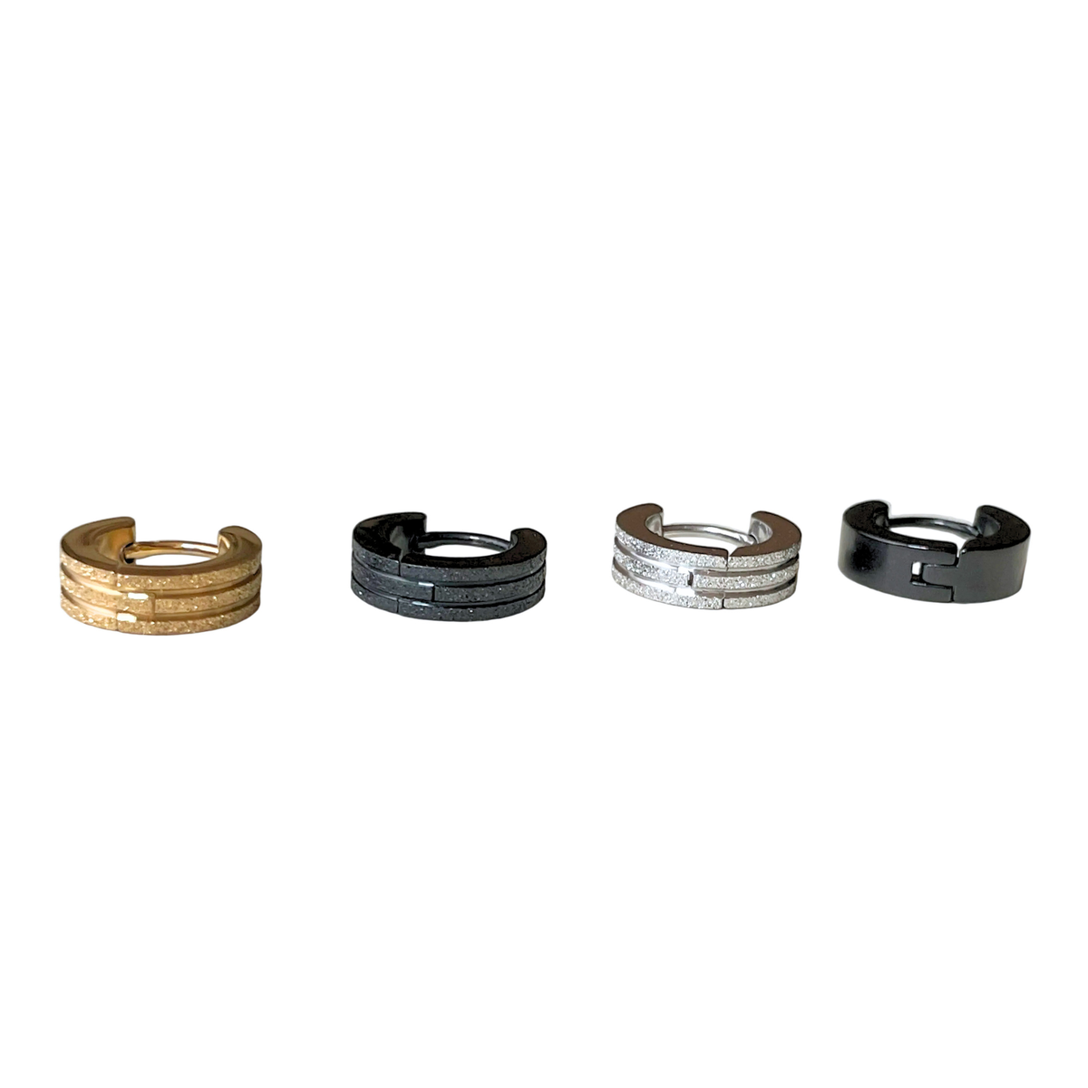 Four small sized stainless steel hoop earrings in different colors on a white background
