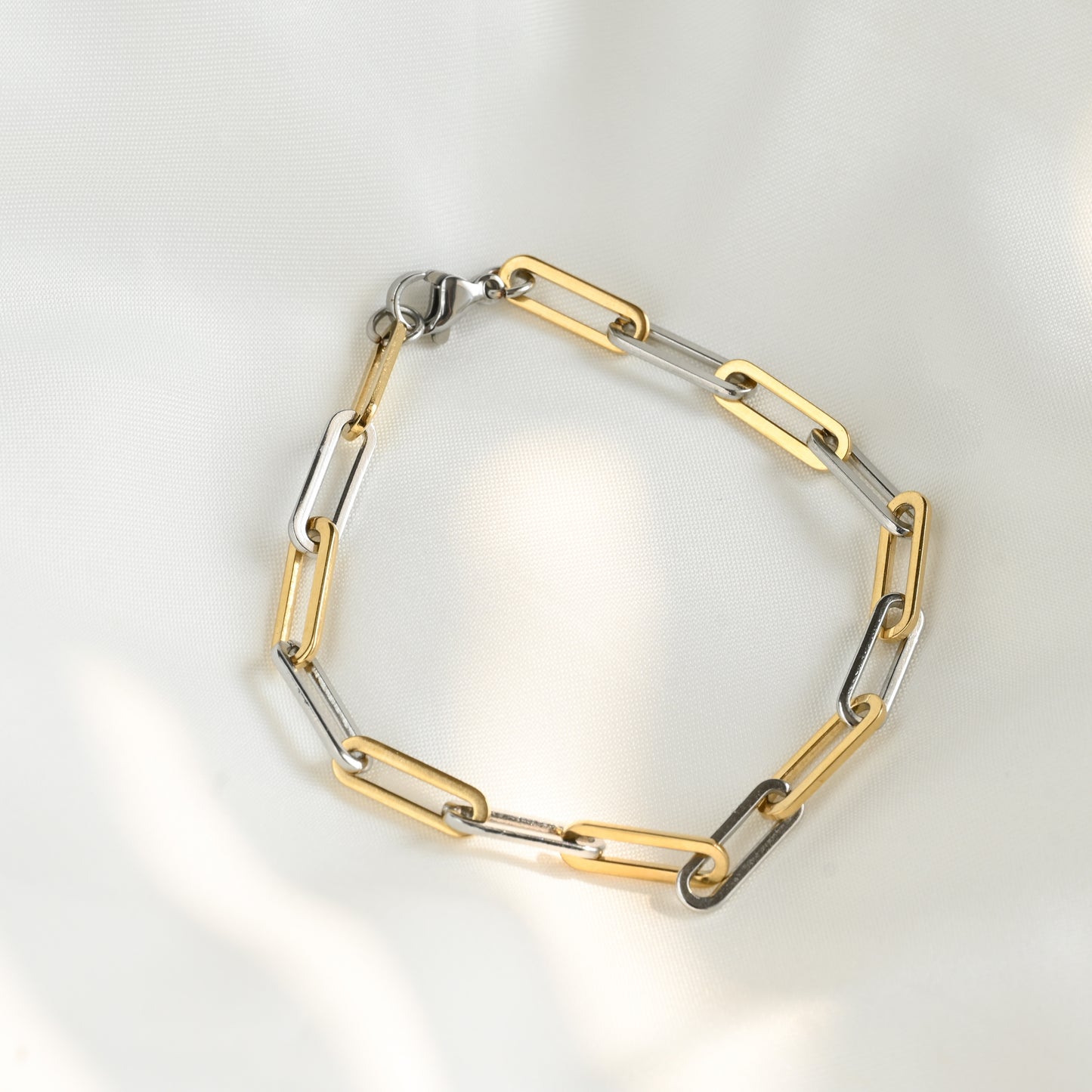 Two-tone chunky chain bracelet on a light gray background