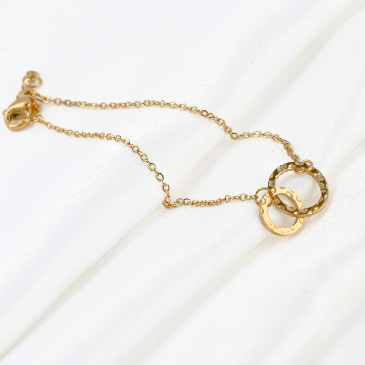 Gold interlocking circle bracelet with a small and medium sized textured circles