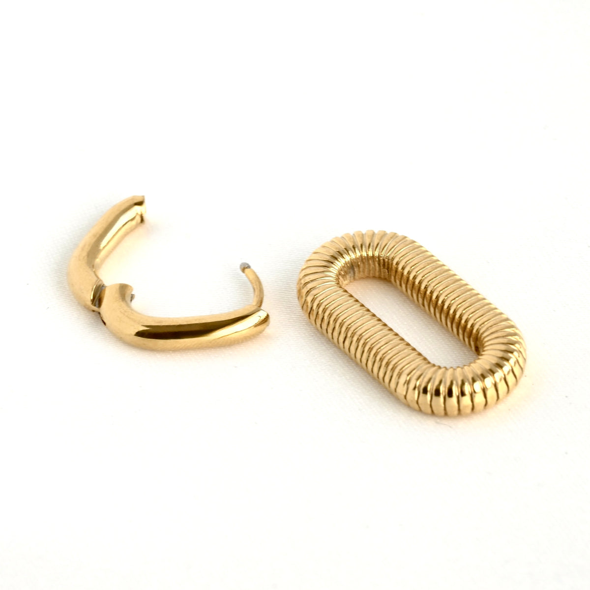 close up of double hoop earrings with the smaller U-shaped earring with hinge being open and the second link is removed and on the side, showing the removable feature of the link.