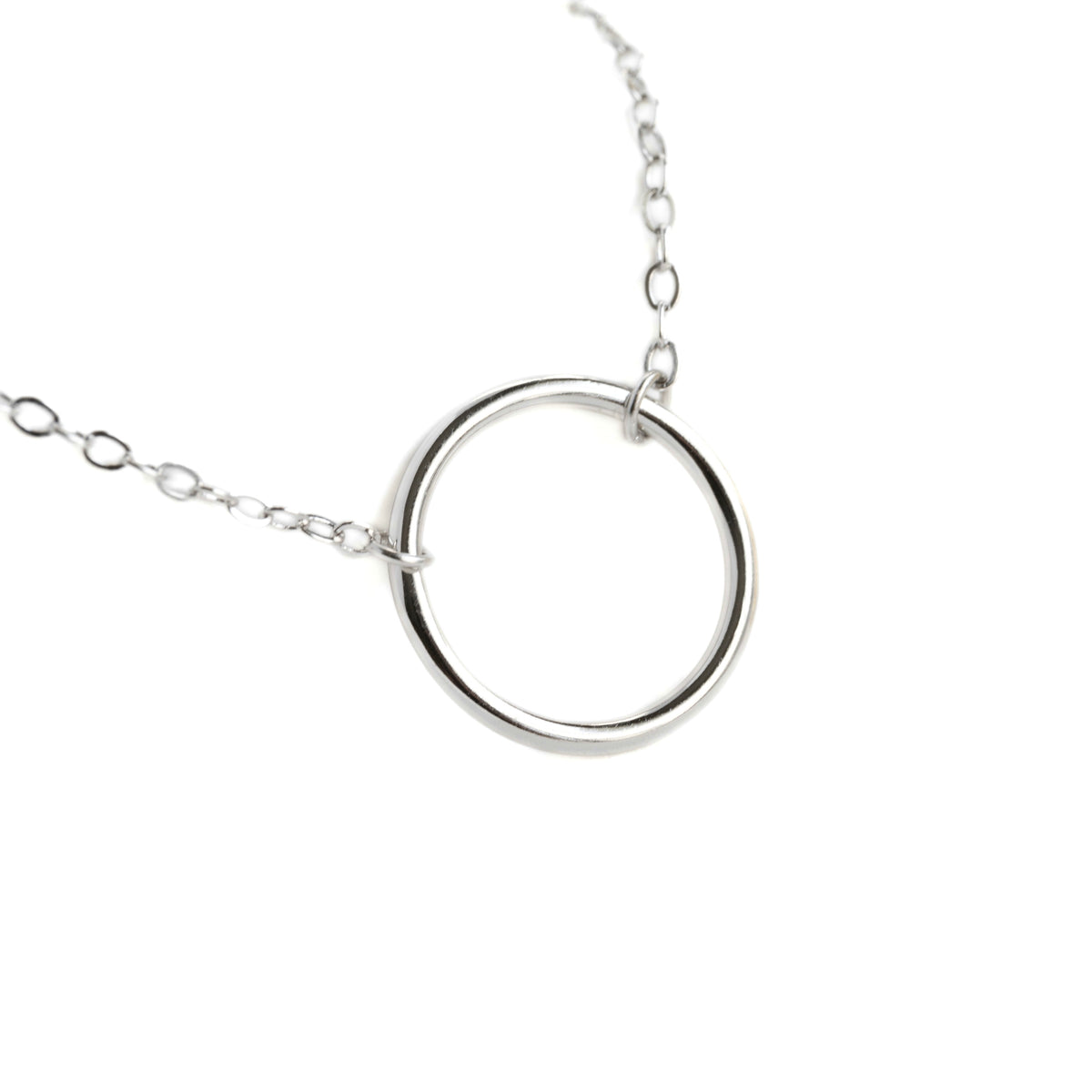 Silver necklace with an open circle charm on a white background