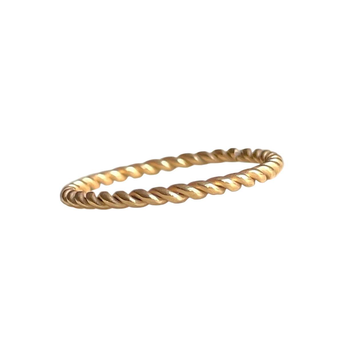 Super slim twisted gold ring on a white background