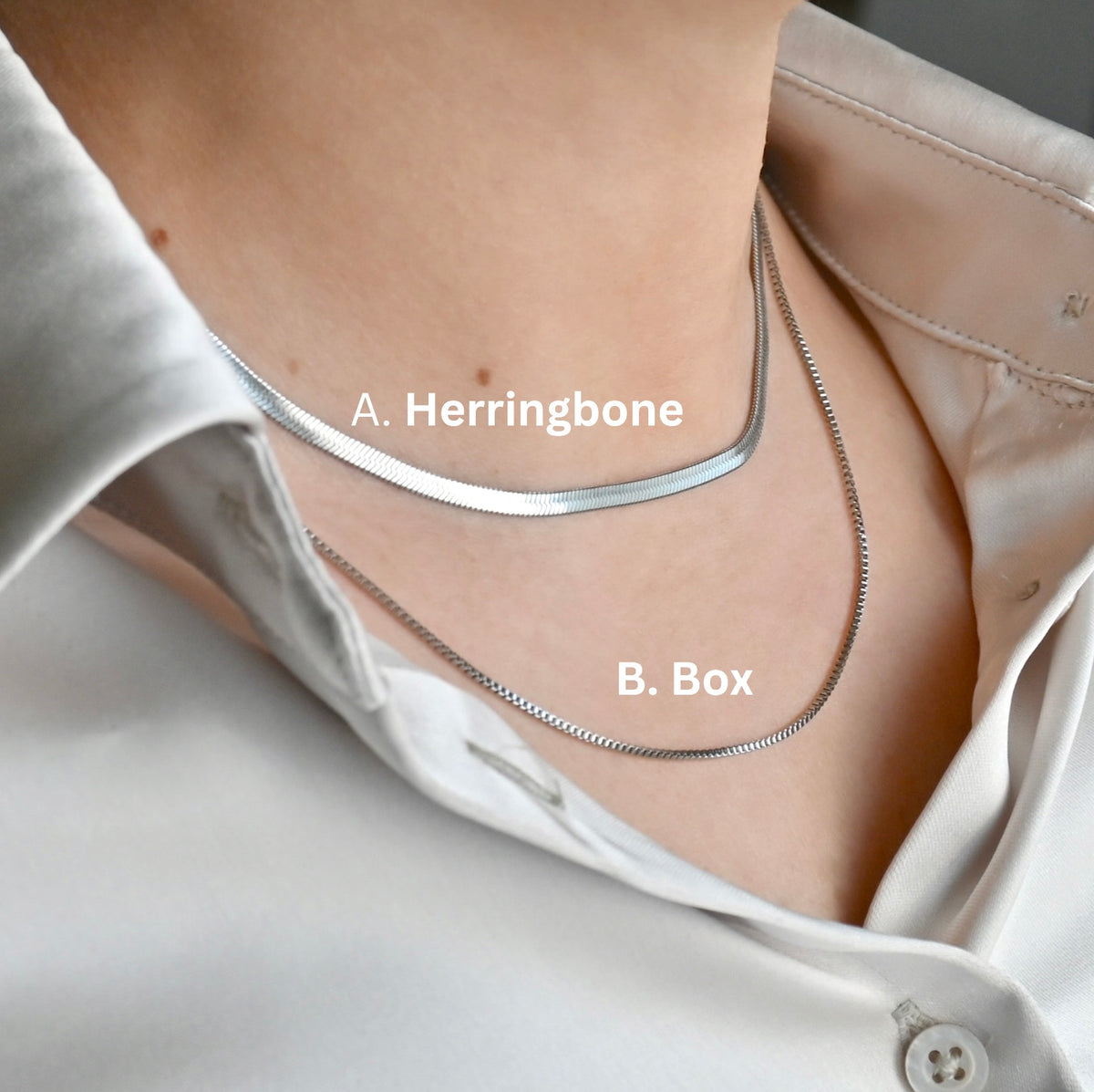 Two silver chain necklaces, one herringbone and a longer 20" box chain, on a person wearing a white shirt.