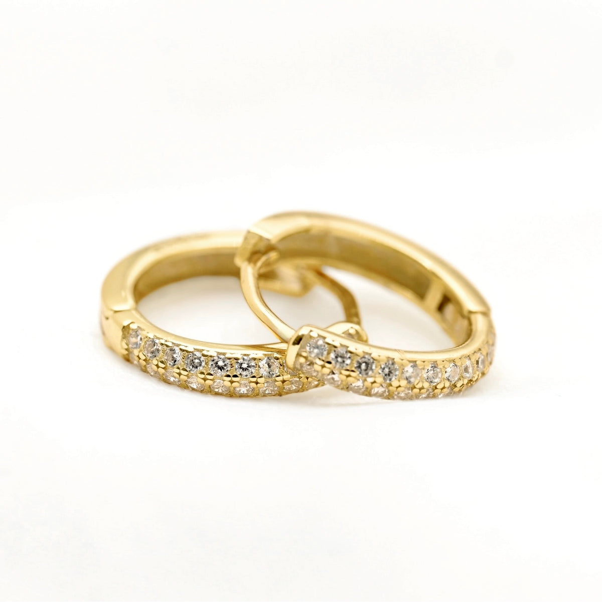 A pair of gold huggie hoop earrings with pavé-set clear stones, shown on a clean white background.