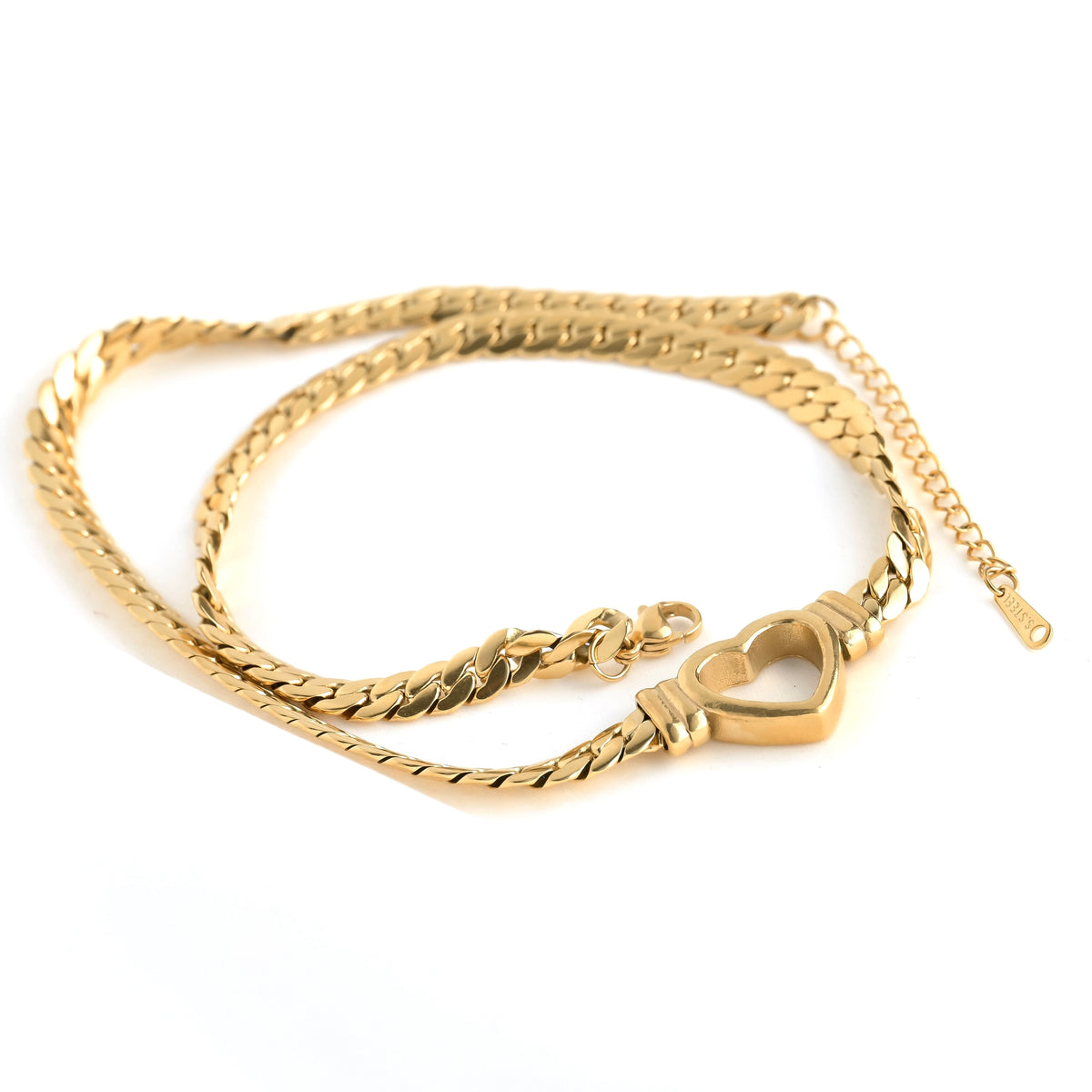 Gold heart pendant necklace with a lobster claw clasp and 'S.Steel' hallmark tag at the end of extender chain on a white background