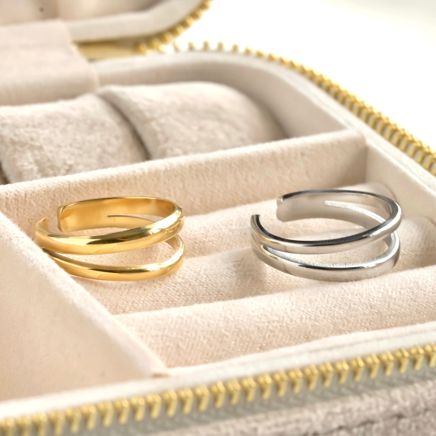Two rings, one gold and one silver, in a jewelry box.