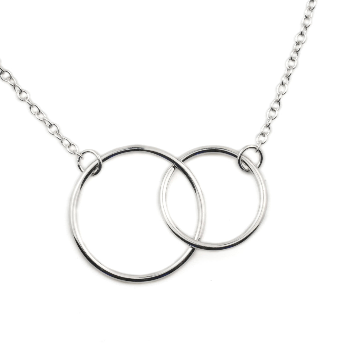 Close-up of silver necklace with interlocking rings on a white background
