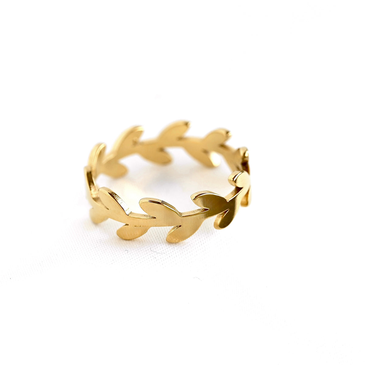 A gold leaf-patterned band ring on a clean white background.