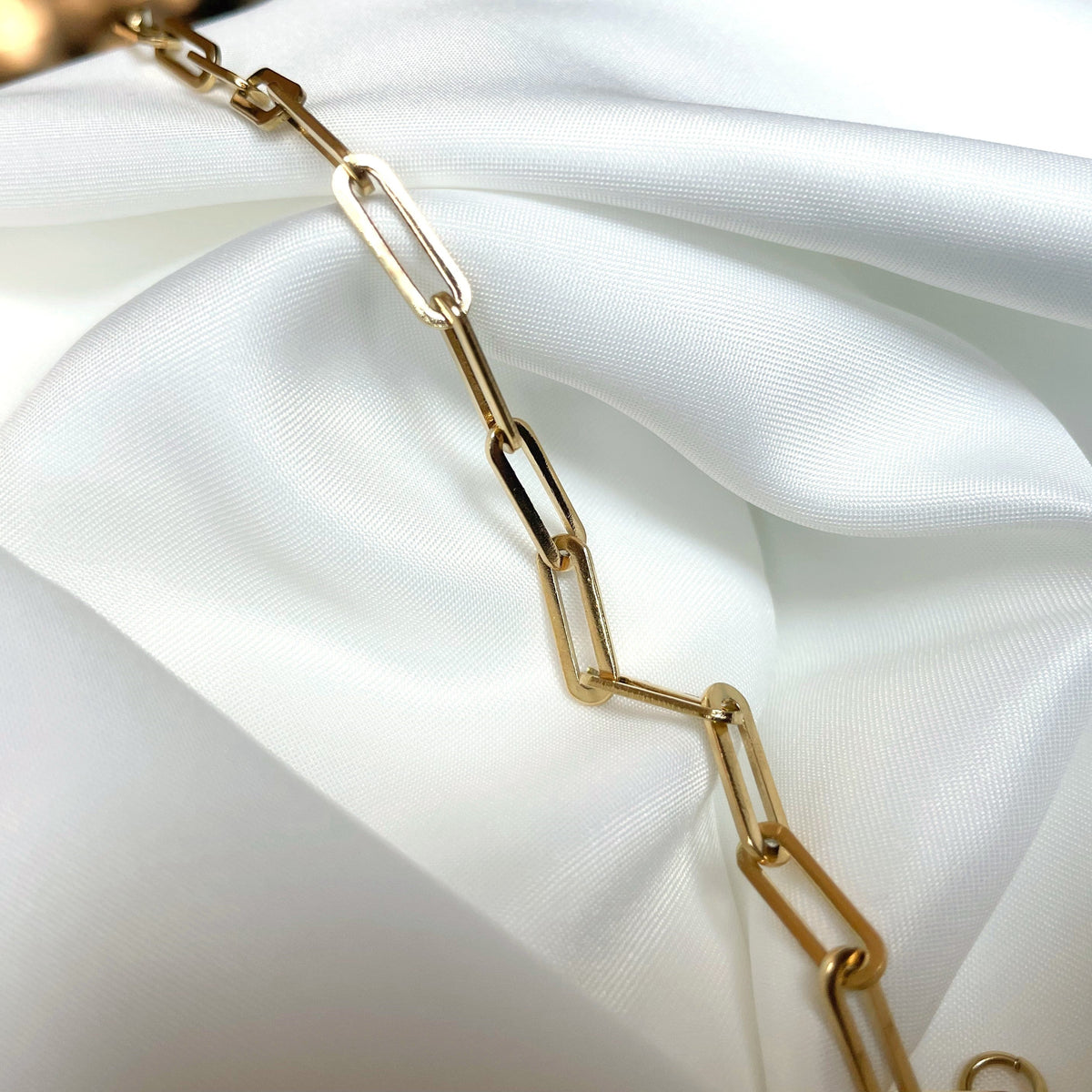 Gold chain on a white fabric background