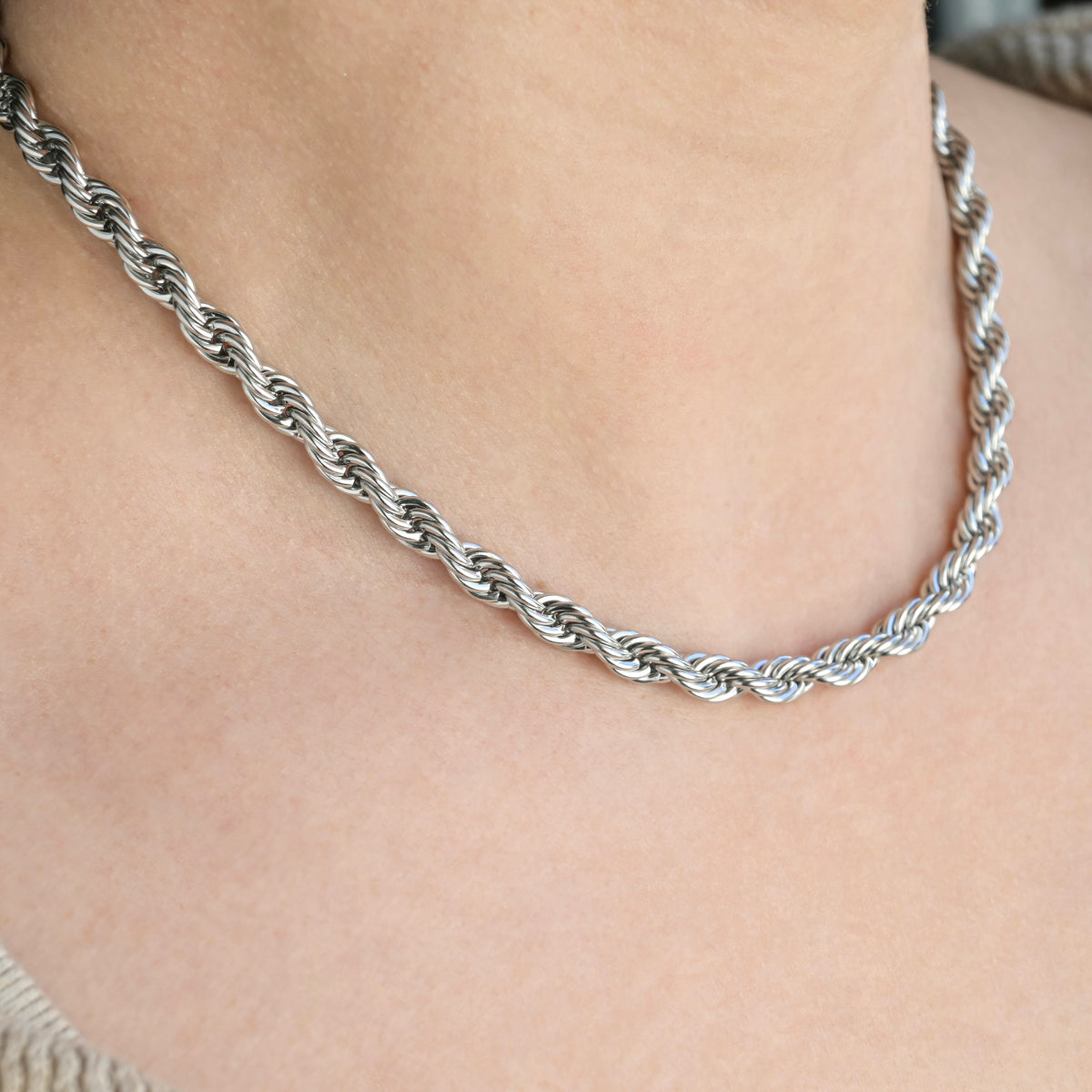 6mm silver rope chain necklace on a person's neck with a neutral background