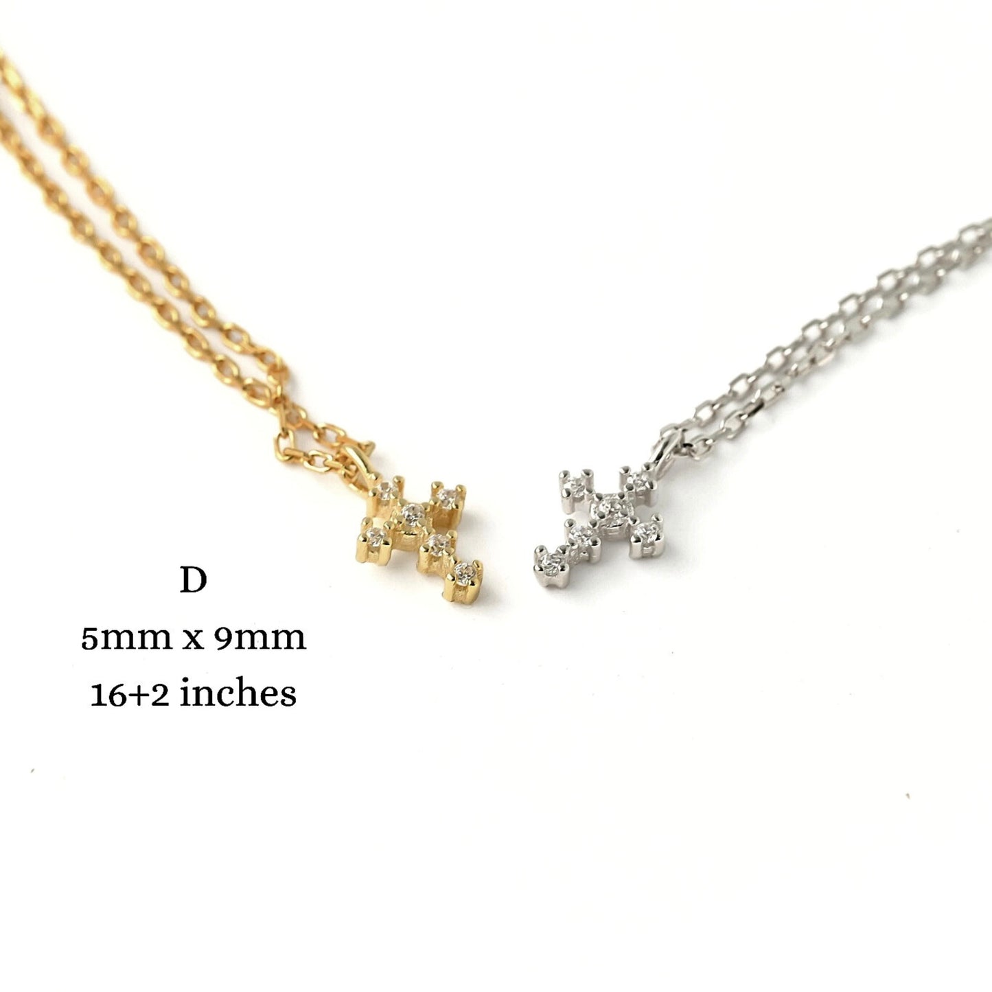Gold and silver tiny cross necklaces on a white background with measurements.