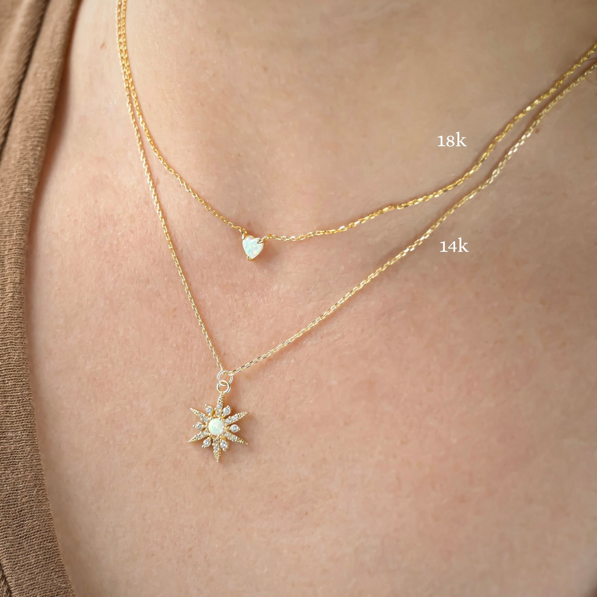 Two gold necklaces with pendants on a person's neck, heart one labeled '18k' and star necklace '14k'.