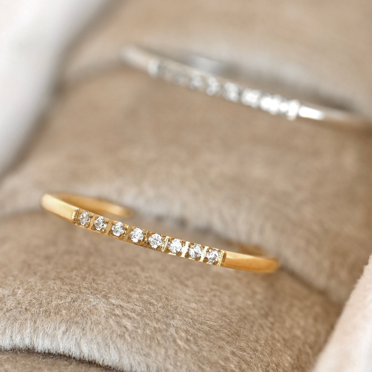 Gold and silver slim cz rings on a soft fabric background