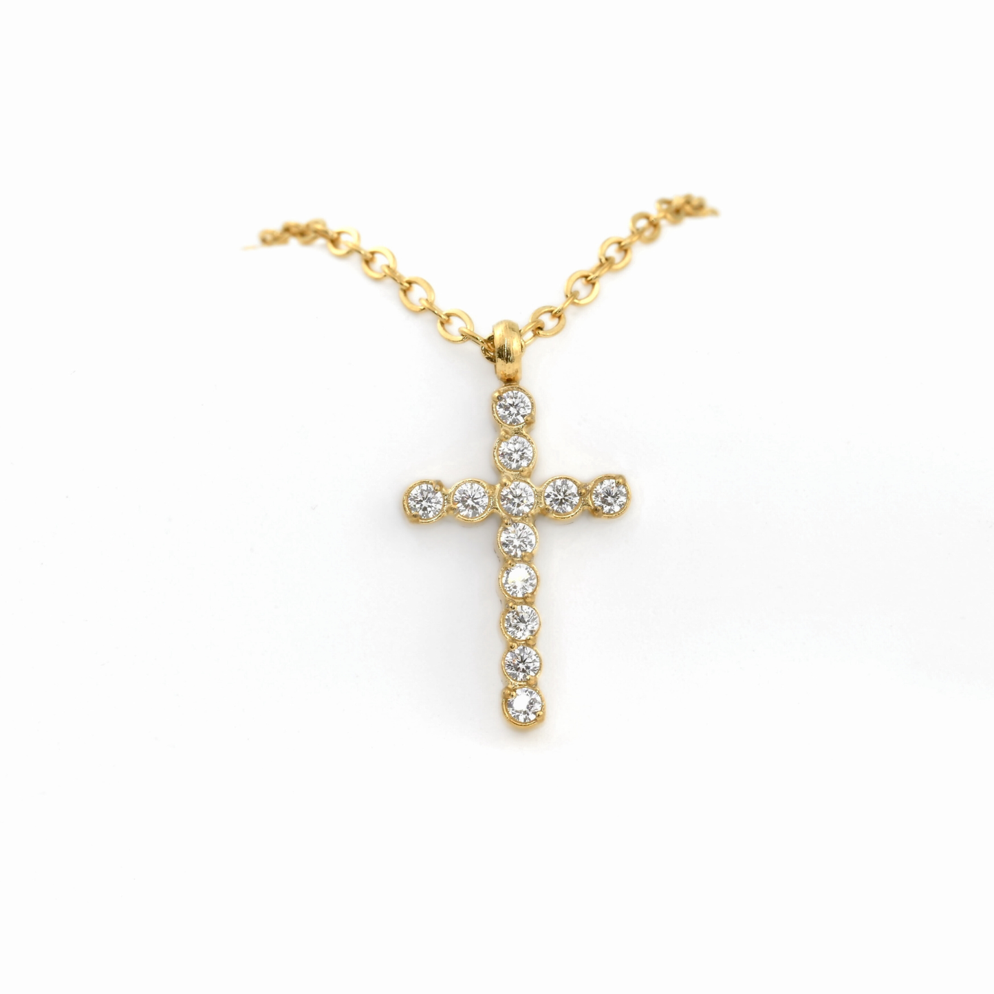Gold cross necklace with round diamonds on a white background