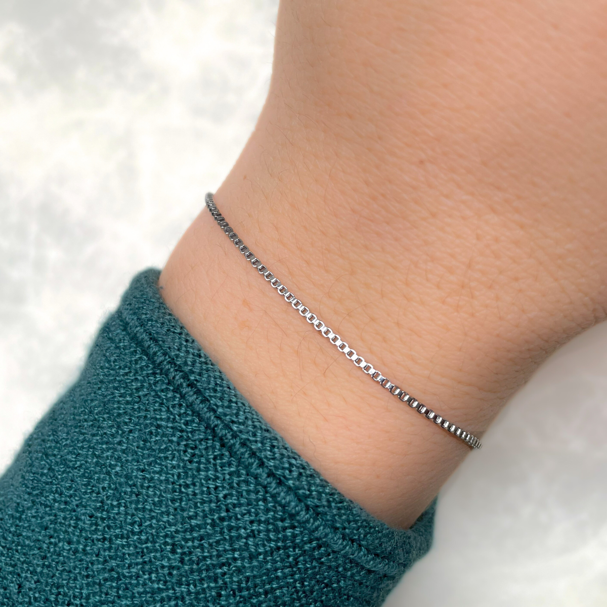 Silver bracelet on a wrist with a blurred background