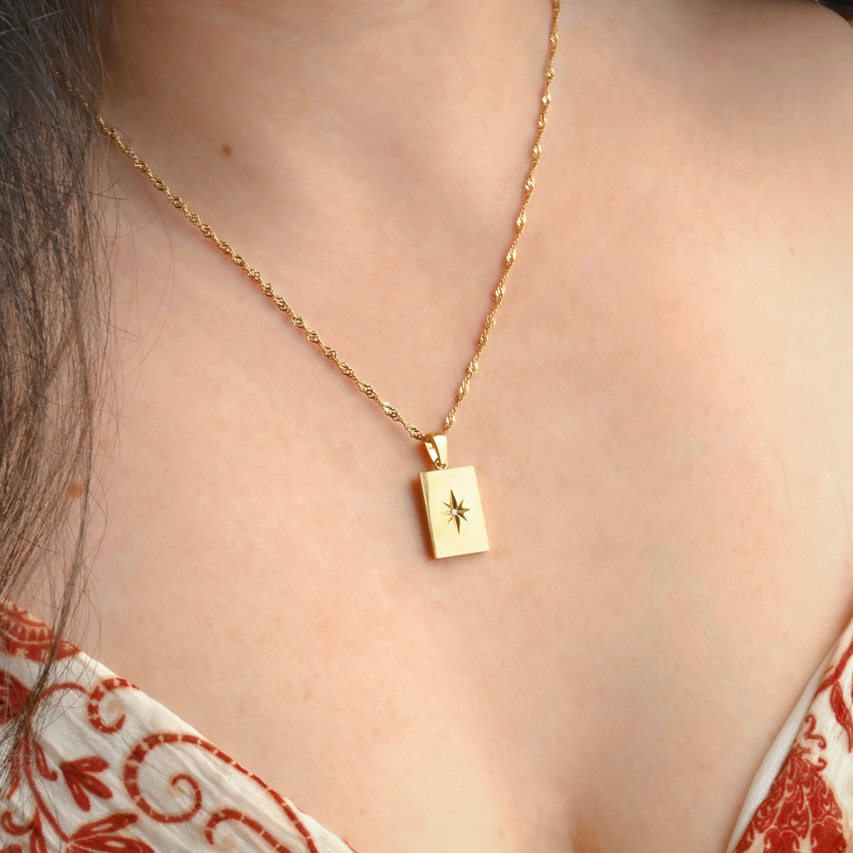 Angled view of north star tag pendant on a person