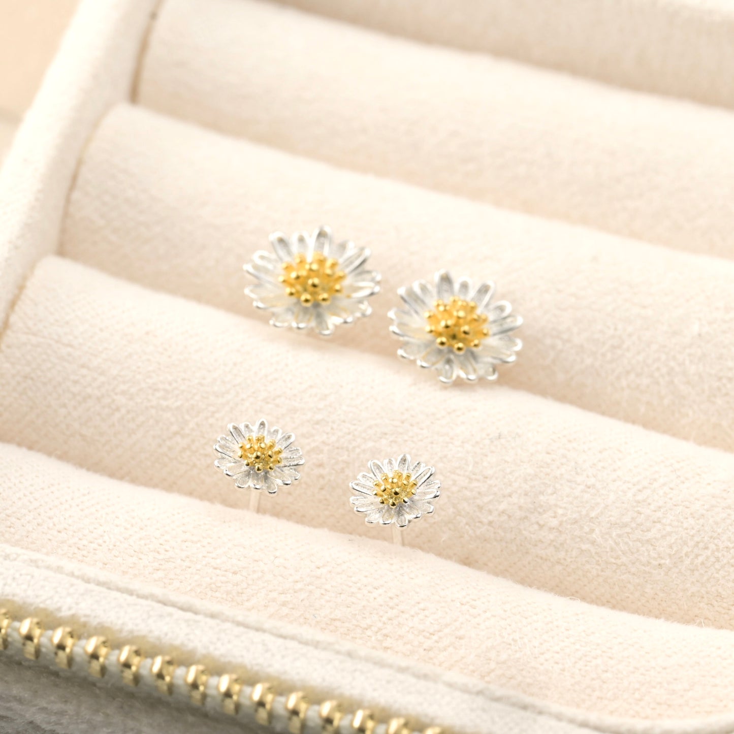 angled view of earrings in a beige fabric jewelry display
