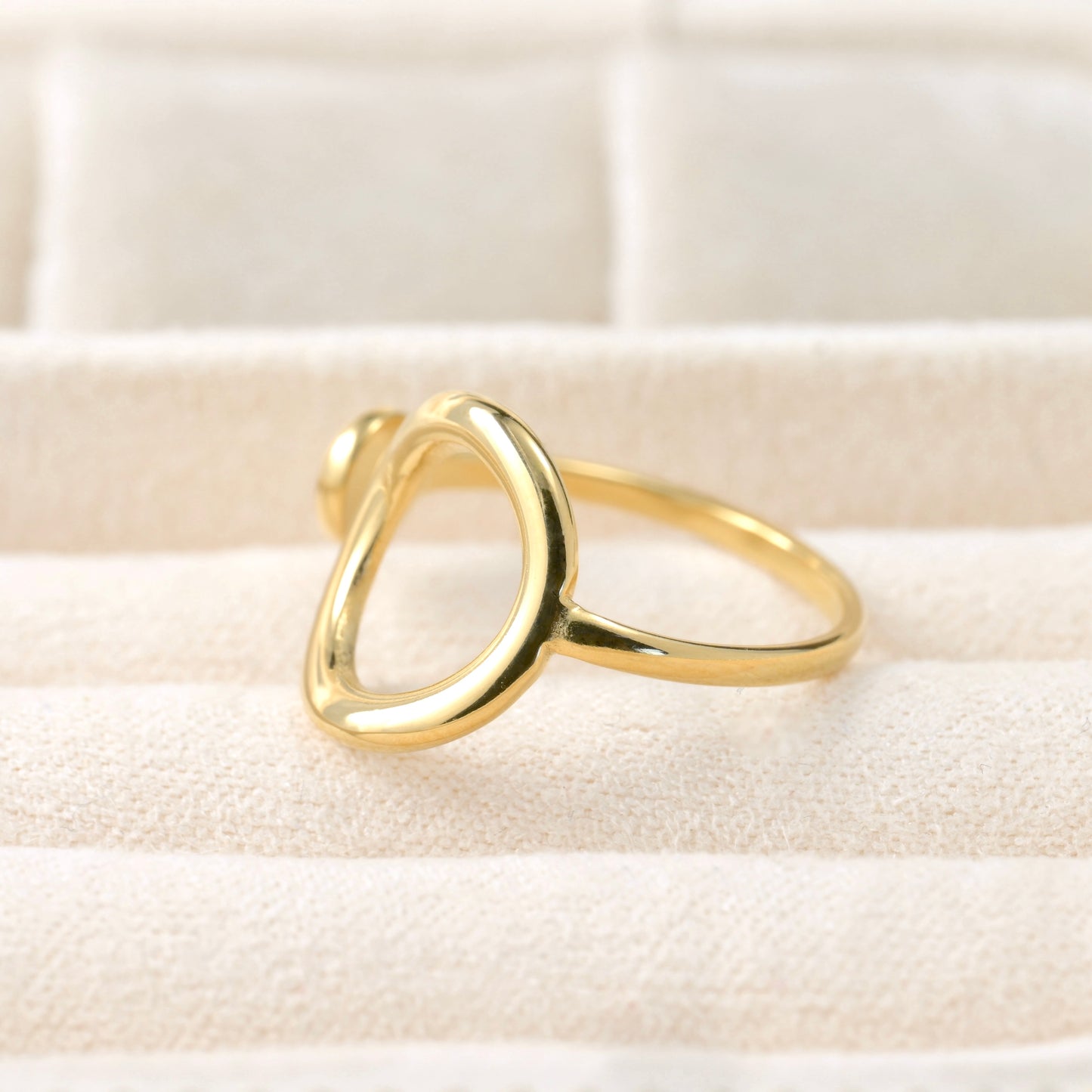 Gold ring on a textured beige surface