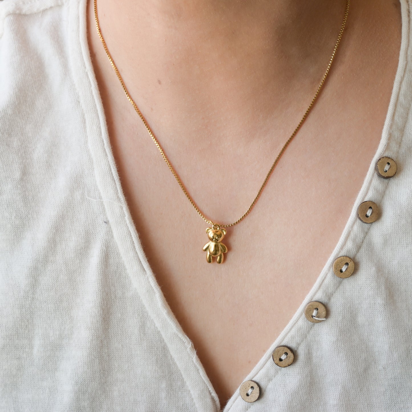 Front view of the bear pendant on a person's neck